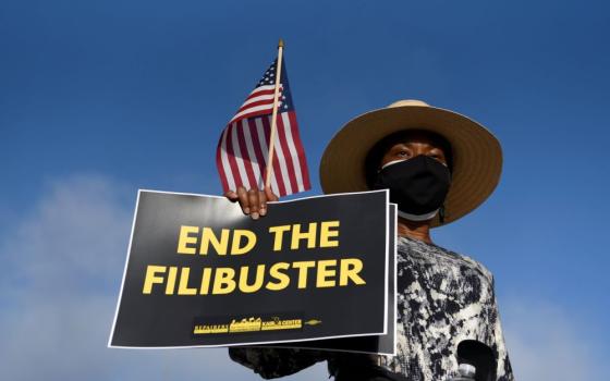 A protester holds a sign ahead of a July 31 march for voting rights in Austin, Texas. (CNS/Reuters/Callaghan O'Hare)