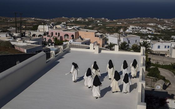 Cloistered nuns walk on a terrace of the Catholic Monastery of St. Catherine on the Greek island of Santorini on June 14. Twice a day, the nuns recess to chat on the convent's wide terraces, the Aegean Sea shimmering in the distance. (AP)
