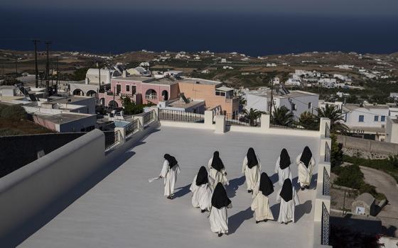 Cloistered nuns walk on a terrace of the Catholic Monastery of St. Catherine on the Greek island of Santorini on June 14. Twice a day, the nuns recess to chat on the convent's wide terraces, the Aegean Sea shimmering in the distance. (AP)