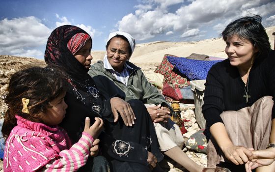 Comboni Sr. Alicia Vacas Moro, right, with Sr. Azezet Habtezghi, center, and a Bedouin family in the desert of Juda on the West Bank after the family's home had been demolished by Israel Defense Forces in 2013 (Courtesy of Sr. Alicia Vacas Moro)
