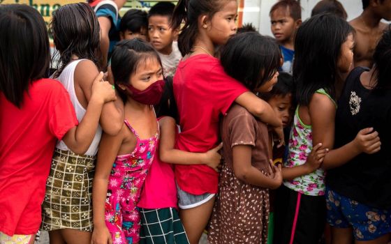 Children wait in line for food from an unidentified relief program in a poor section of Manila, Philippines, Jan. 21, 2021, during the COVID-19 pandemic. (CNS/Reuters/Eloisa Lopez)