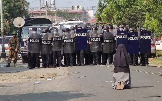 Sr. Ann Nu Thawng, a member of the Sisters of St. Francis Xavier, kneels in front of police and soldiers during an anti-coup protest Feb. 28 in Myitkyina, Myanmar. (CNS/Courtesy of the Myitkyina News Journal)