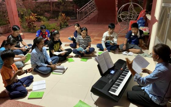 Lovers of the Holy Cross Sr. Hill Pen leads choir practice on a Saturday evening at the Catholic church in Stung Treng, Cambodia, earlier this year. (Akarath Soukhaphon)
