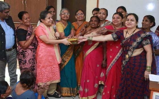 Sr. Christin Mary (in pink, holding microphone), a member of the Missionary Sisters of the Immaculate Heart of Mary and a coordinator of the National Domestic Workers' Movement, with a group of domestic workers in February 2019 in the western Indian city 