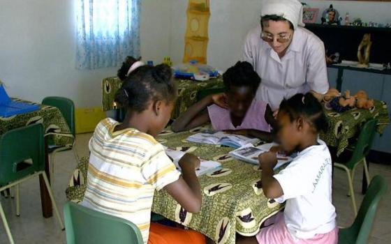 A Sister of St. Vincent de Paul of Lendelede with children at the St. Vincent de Paul Children Rehabilitation Center for daily care. This photo has been edited to protect the children's identities. (Aimable Twahirwa)