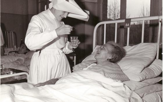 A Daughter of Charity tends to a sick person in Italy in the 1950s. (©Archives of the Daughters of Charity, Paris)