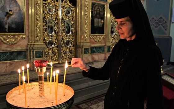 Sr. Evphrosynia Senyk, a member of the Congregation of the St. Joseph's Sisters of the Ukrainian Catholic Church, lights a candle in the sanctuary of the Greek Catholic Parish of the Exaltation of the Holy Cross, in Krakow, Poland. (GSR/Chris Herlinger)