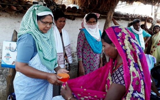 From left: Sr. Josephine Kisku, Sr. Sushma Ekka and Sr. Susan Tudu, all Sisters of Charity of Nazareth, distribute food in Chatra, India. (Courtesy of the Sisters of Charity of Nazareth)