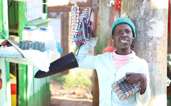 Mary Wanjiku, 26, displays one of her beaded products next to her shop in Limuru, a town in central Kenya. Wanjiku is a beneficiary of the Limuru Cheshire Home, a charitable institution for girls living with disabilities in Kenya. (Wycliff Oundo)