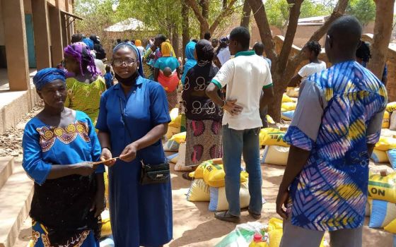 Sr. Ojonoka Acheneje, a Daughter of Charity of St. Vincent De Paul, distributes food to internally displaced persons in the Diocese of Nouna, Burkina Faso. (Courtesy of Janet E. Deinanaghan)