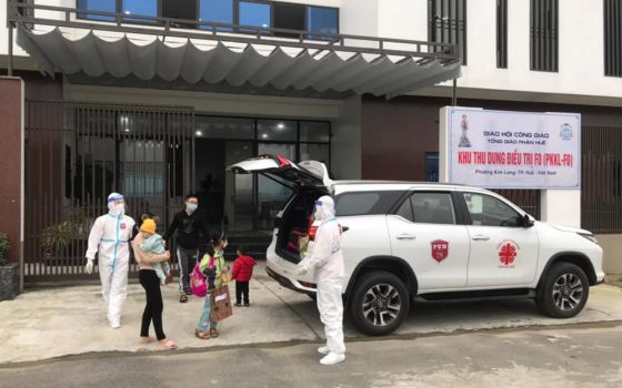 Religious volunteers in medical gear drive patients who have fully recovered from COVID-19 from Kim Long Charity Clinic in Kim Long ward in Hue, Vietnam, to their home Feb. 28. (Joachim Pham)