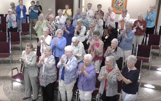 Sisters in the Adrian Dominican auditorium in Adrian, Michigan, give Dominican Sr. Elise García a standing ovation at the conclusion of her Aug. 11 presidential address to the Leadership Conference of Women Religious. (GSR screenshot)