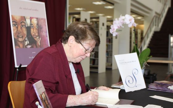 Sr. Lou Ella Hickman signs a copy of her book, she: robed and wordless, at La Retama Central Library in Corpus Christi, Texas, during a presentation May 1. (Courtesy of the Sisters of the Incarnate Word and Blessed Sacrament)