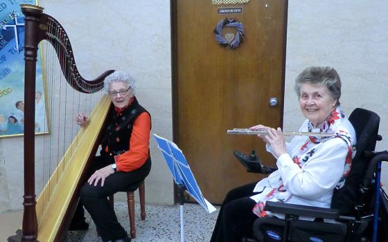 Dominican Sr. Mary Anna Euring, right, plays flute with Sr. Miriam Cecile Lenihan on the harp in 2016. Lenihan died last year. (Courtesy of Sr. Mary Anna Euring)