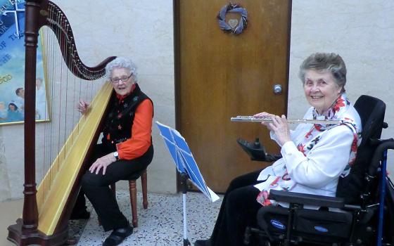 Dominican Sr. Mary Anna Euring, right, plays flute with Sr. Miriam Cecile Lenihan on the harp in 2016. Lenihan died last year. (Courtesy of Sr. Mary Anna Euring)