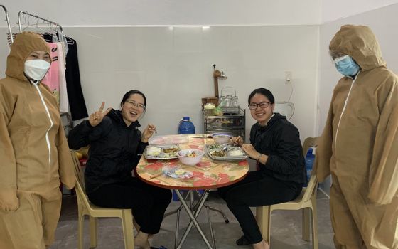 Sr. Mary John Théophan Vénard Doan Thi Chuyen, far left, and another sister in medical gear serve a meal to two nuns with COVID-19 at Ho Ngoc Can Clinic in Xuan Truong district, Nam Dinh province. (Daughters of Our Lady of the Holy Rosary of Bui Chu)