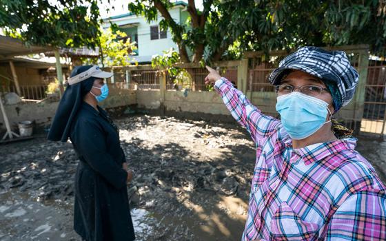 Srs. Milena Vanegas, left, and Victoria Emérita in the mud-covered playground of the nursery school they operate in La Planeta, a neighborhood of La Lima, Honduras, in late January.