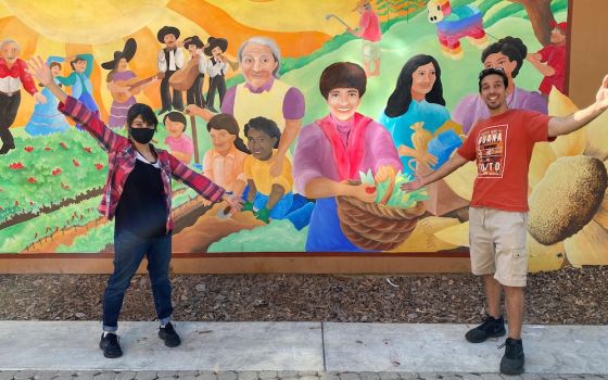 Notre Dame Mission Volunteers-AmeriCorps Jennifer Castro-Lara, left, and Samuel McCoy pose in October by a mural at the St. Francis Center in Redwood City, California