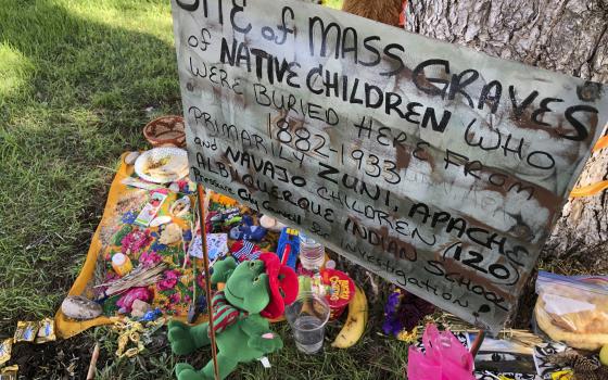 A makeshift memorial for the dozens of Indigenous children who died more than a century ago while attending a boarding school that was once located nearby is displayed under a tree in Albuquerque, N.M., on July 1, 2021 (AP Photo/Susan Montoya Bryan, File)