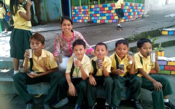 Sr. Sujata Jena in July 2019 with elementary children in the "Glass of Milk" program coordinated by the Sacred Heart Sisters, Bagong Silang, Philippines (Courtesy of Sujata Jena)