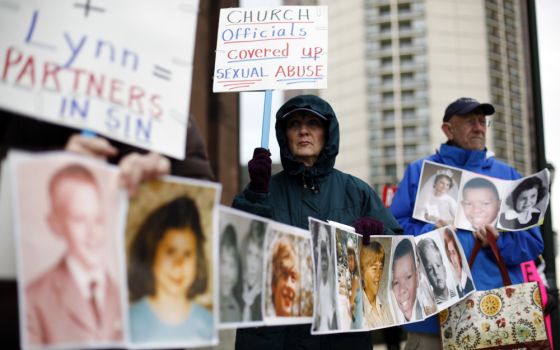 Catherine Coleman Murphy, center, and Jack Wintermyer, right, protest along with others outside Cathedral Basilica of Sts. Peter and Paul before an Ash Wednesday Mass in Philadelphia on March 9, 2011. (AP/Matt Rourke)