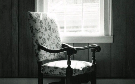 black and white upholstered chair by window with light coming in