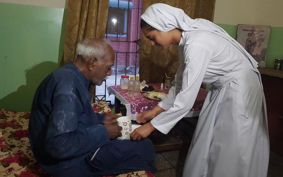 A Sister of Charity of Jesus and Mary serves tea to a resident of Shakina Home for the Aged in Youhanabad, Lahore, Pakistan. (Kamran Chaudhry)