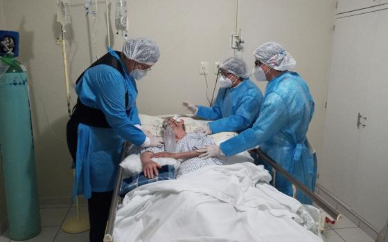 Members of the Daughters of Mary Immaculate of Guadalupe tend to a COVID-19 patient in the sisters' health service. (Courtesy of the International Union of Superiors General)