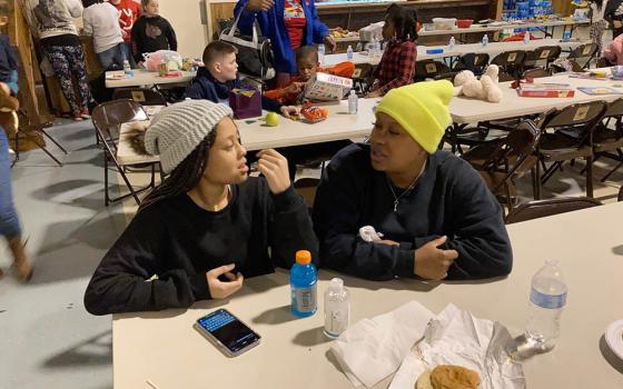 Courtney Saxton chats with her 13-year-old daughter, Querria, at the St. Jerome Parish hall in Fancy Farm, Kentucky, on Dec. 11. The family's Mayfield, Kentucky, home was destroyed by a tornado. (AP/Bruce Schreiner)