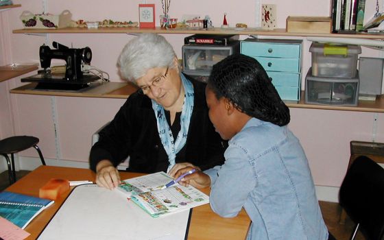 Good Shepherd Sr. Marie-Hélène Halligon, left, teaches the French language to a survivor of trafficking. (Courtesy of Marie-Hélène Halligon)
