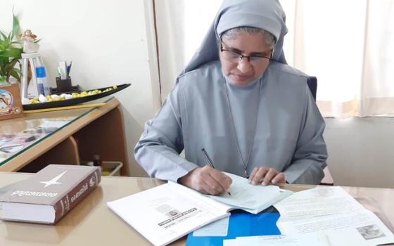 Sr. Tessy Kodiyil of the Congregation of the Holy Family writes letters to relatives of accident victims in her office at Aswas in Changampuzha Nagar, Kochi, in the southern Indian state of Kerala. (Courtesy of Tessy Kodiyil)