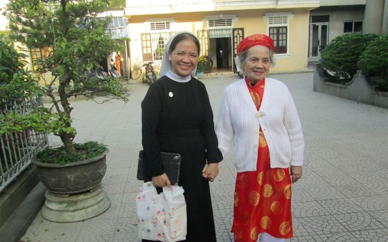 Sr. Maria Bach Thi Tuyen of the Daughters of Our Lady of the Visitation, left, and her mother pay visits to their relatives and neighbors in Phu Cat commune in Hue, Vietnam, during this year's Tet or Lunar New Year festival. (Joachim Pham)