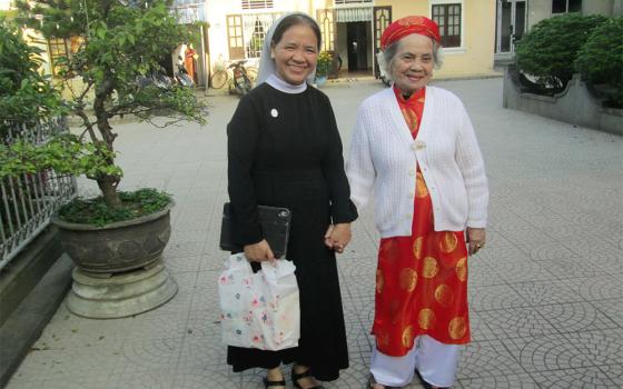 Sr. Maria Bach Thi Tuyen of the Daughters of Our Lady of the Visitation, left, and her mother pay visits to their relatives and neighbors in Phu Cat commune in Hue, Vietnam, during this year's Tet or Lunar New Year festival. (Joachim Pham)