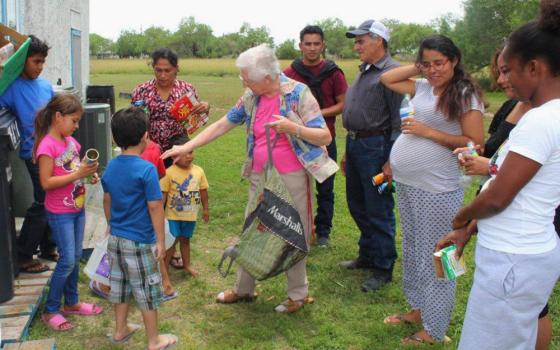 Sr. Thérèse Cunningham, center, spends pre-pandemic time with guests at La Posada Providencia, an emergency shelter in San Benito, Texas.