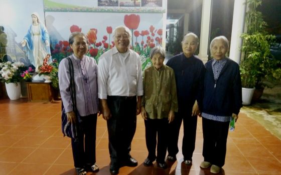 Jesuit Fr. Thomas Vu Quang Trung and Sisters of Providence of Tay Nguyen, Vietnam, pose for a photo at their convent. (Joachim Pham)