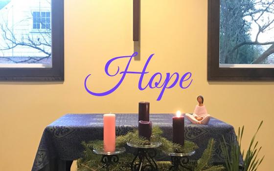 Image: An Advent wreath with one purple candle lit in front of an altar with a cross hanging above it. Superimposed over the image in purple is the word "hope."