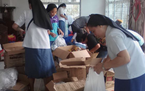Within days after the typhoon hit, Missionary Sisters of Mary sisters sort through donated goods to repack and send to various communities in need, in Lapu-Lapu City, Cebu province, in the Philippines. (Courtesy of Missionary Sisters of Mary)