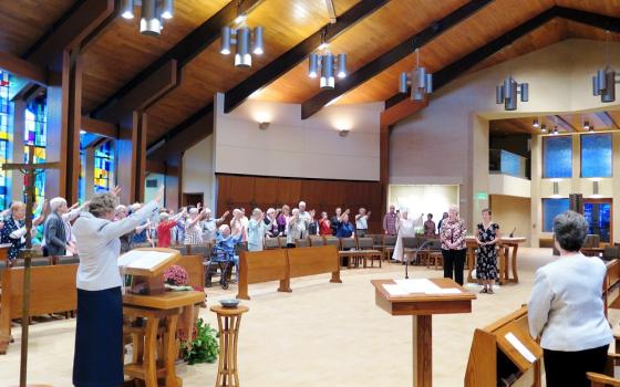 The Benedictine Sisters of Erie, Pennsylvania, bless Sr. Valerie Luckey, in black dress, at her first profession Oct. 21, 2017. (Courtesy of the Benedictine Sisters of Erie)