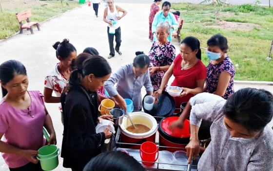 Lovers of the Holy Cross of Hue Sr. Anna Nguyen Thi Hien, center, serves chao to patients' relatives in the hospital yard of Quang Tri General Hospital. (Joachim Pham)