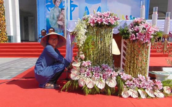 Sr. Agnes Nguyen Thi Tuyet Suong arranges flowers on a stage at the national Shrine of Our Lady of La Vang in Quang Tri province, in Vietnam. (Joachim Pham)