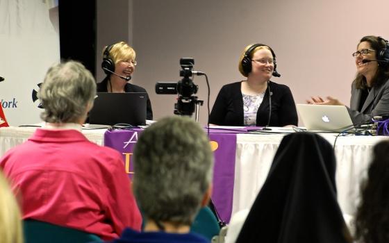 Four women in headsets at a table