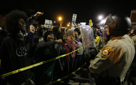 Protesters square off against police in riot gear during an Oct. 11 rally for Michael Brown outside the police department in Ferguson, Mo. (CNS/Reuters/Jim Young)