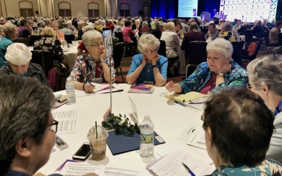 Sisters share their thoughts with the other sisters at their tables after a keynote speaker at the 2018 Leadership Conference of Women Religious annual assembly, held Aug. 7-10 in St. Louis. (GSR file photo)