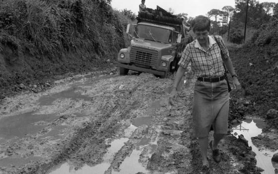 Sr. Melinda Roper walks along a muddy road in Panama, 1988. (Provided by Maryknoll Sisters)