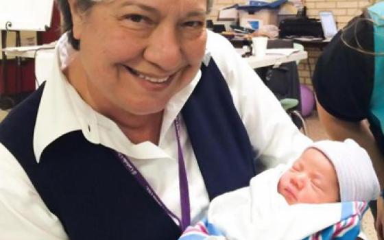 Missionaries of Jesus Sr. Norma Pimentel holds a newborn baby at the humanitarian respite center she started at Sacred Heart Church during an immigration surge in 2014. (Herminia Forshage/Courtesy of Catholic Charities of the Rio Grande)