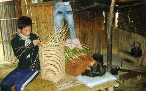 Ho Van Son, a 14-year old ethnic Pa Co, makes a bamboo basket for a living, looking after his bedridden mother suffering from a serious lung disease. Son left school eight years ago. (Peter Nguyen)