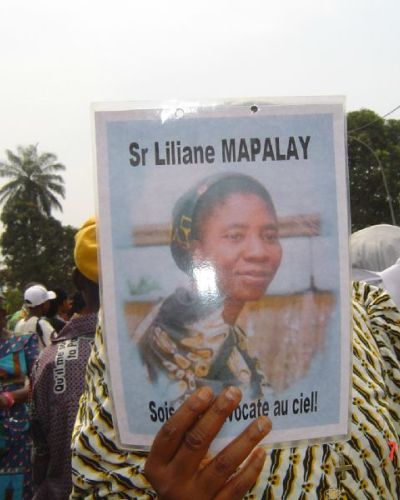 A funeral guest holds a flier depicting Sr. Liliane Mapalayi.