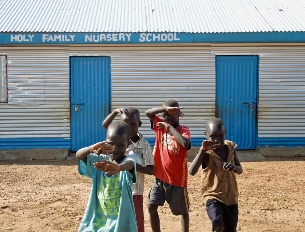 Children mug for the camera outside of a nursery school run by the Charity Sisters of Jesus at a settlement near Adjumani, northern Uganda. 